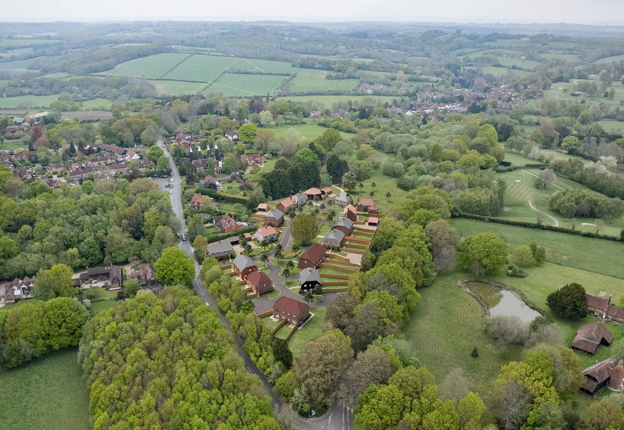 Aerial drone photomontage CGI. Aerial photomontage showing residential development integrated into drone imagery with surrounding greenery.